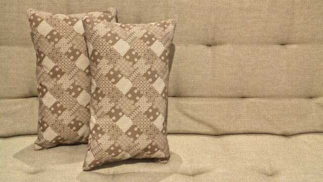 Two Batik Patterned Throw Pillows on Beige Sofa Living Room Interior Close Up