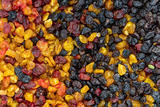 Colorful assortment of dried grapes in golden red and black hues piled high together at a local bazaar stall showcasing their natural variety texture and abundance, Gyumri, Armenia