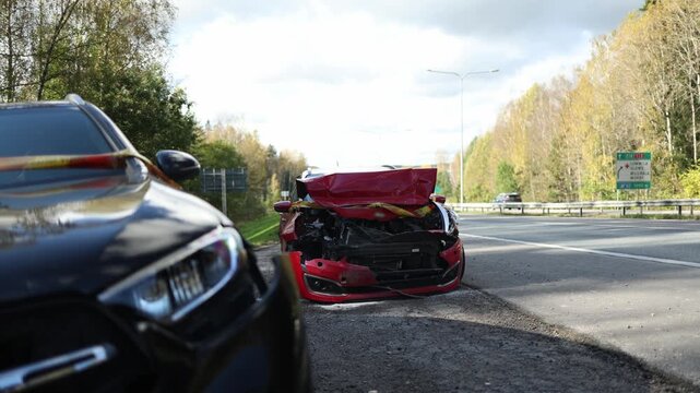 Two cars with visible collision damage remain stationary with emergency flashers active capturing the aftermath of a traffic incident on an urban roadway after a sudden road impact