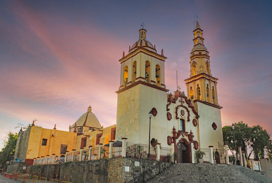 Historic Santiago Apostol church with twin bell towers and colonial architecture under a clear blue sky in Santiago, Nuevo Leon, Mexico.