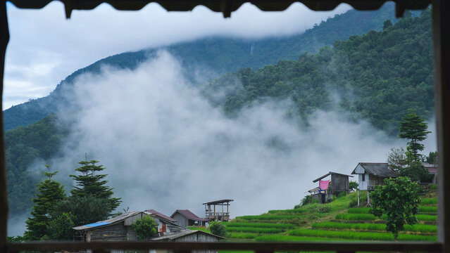 Rice terrace and wooden huts in the mountains on cloudy morning