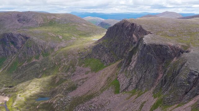 Aerial Drone View of Dramatic Rocky Cliff Face and Mountain Loch in Cairngorms National Park Scotland