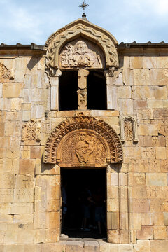 Medieval stone facade of Surb Karapet monastery church featuring a carved depiction of God the Father above the entrance beside a steep stone staircase, Noravank, Armenia