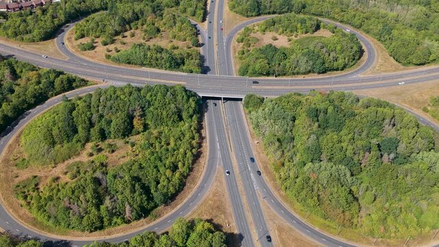 Aerial View of a Highway Interchange With Cars Driving Through Lush