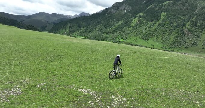 Aerial footage of woman riding mountain bike on beautiful forest mountain trail