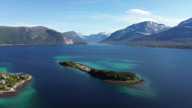 Aerial Drone View of Forested Peninsula in Norwegian Fjord with Snow-Capped Mountains Norway