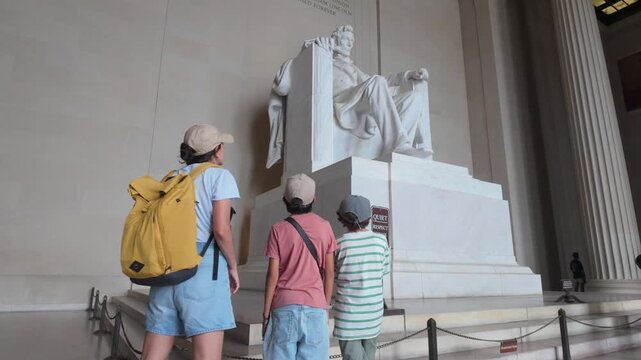 Family of tourists with children visiting and admiring the famous abraham lincoln memorial statue, a national monument and landmark in washington, d.C., usa during their vacation
