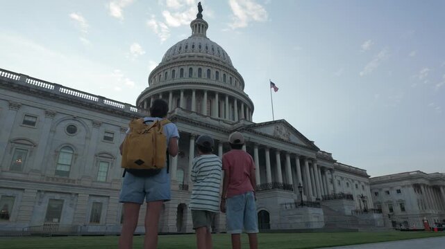 Three curious children standing together and looking up at the majestic dome of the united states capitol building in washington d.C., a symbol of american democracy and freedom