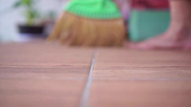 broom bristles brushing across a smooth floor surface. Cleaning footage capturing tidiness, chores, and home maintenance.