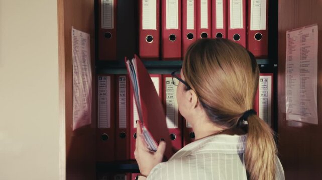 Female Employee Organizing Paperwork in Corporate Archive