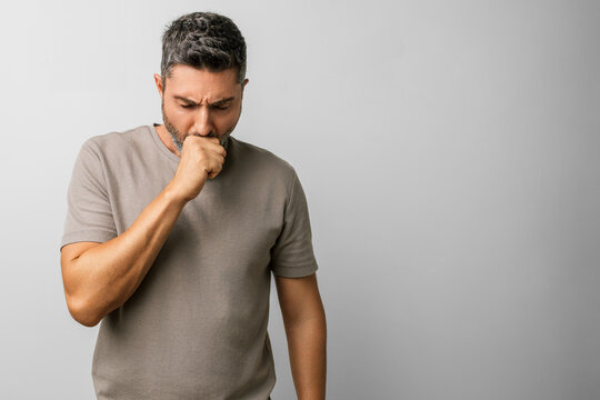 Man caucasian gray hair beard t shirt cough coughing cold studio portrait - unwell, seeking health care and care for bronchitis; health-focused portrait of a sick middle-aged male