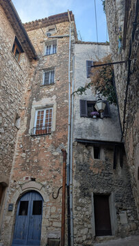 Historic stone houses in a narrow alley in Tourrettes-sur-Loup, France. 