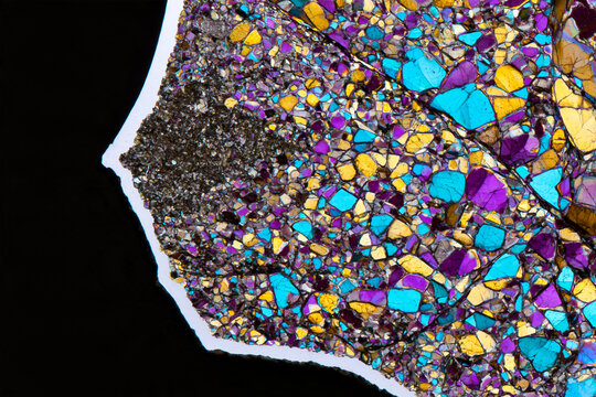 Thin slice of rock under polarised light showing mosaic colours, petrography