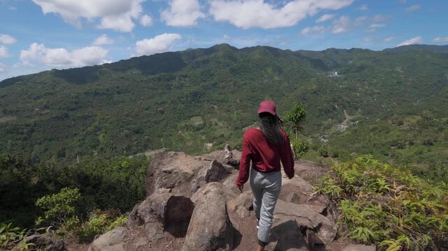 Asian Young Woman Climbs A Mountain in Asia, Travels through the Jungle among Palm Trees in Sunny Weather