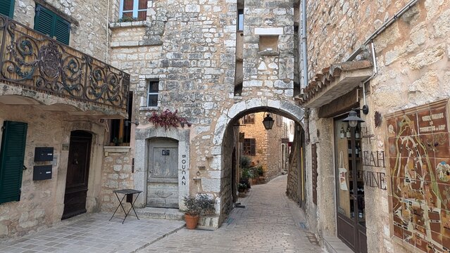 Tourrettes sur Loup, France &ndash; September 28, 2026: Stone archway and narrow street with shops in the historic village center. 