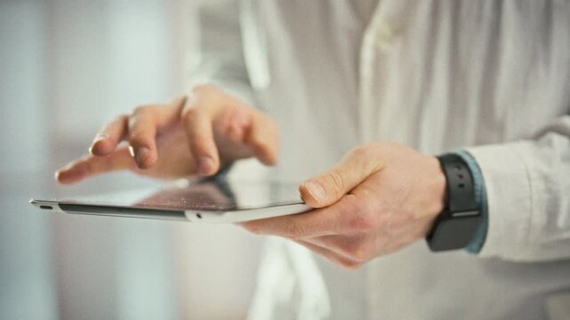 Doctor studies a panoramic x-ray on a digital tablet, pinching to zoom and scrutinizing damaged zones. This focused medical professional action supports accurate diagnosis and treatment in healthcare