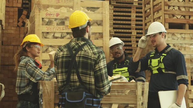 Team male and female carpenters is inspecting selecting rectangular hardwood pieces stored in wooden crates intended production heavy duty pallets such construction cargo handling industries.