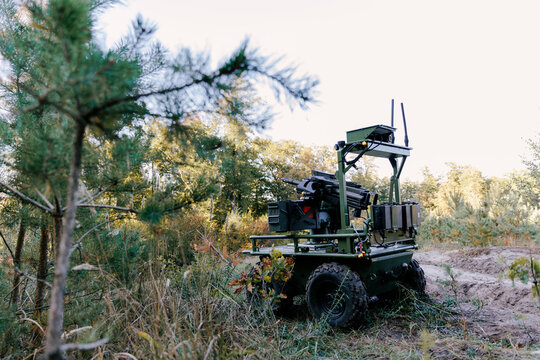 Unmanned ground vehicle patrolling forest area with weapon system