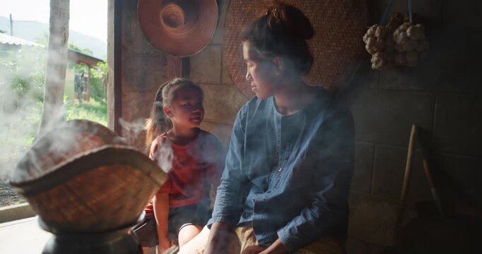 Steam rises from a woven bamboo basket as sticky rice steams over a clay pot, with a daughter sitting nearby in a rural Thai kitchen.