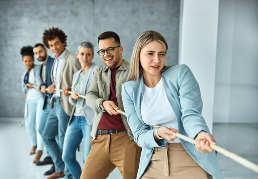 Portrait of a young  businesspeople pulling a rope in the office