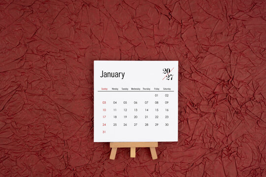 January 2027 calendar on red crumpled paper background. Directly above.