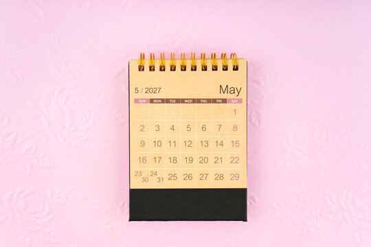 Desk calendar for May 2027 on flower pattern embossed as background.
