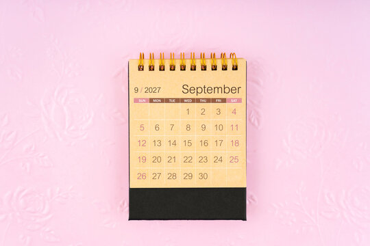 Desk calendar for September 2027 on flower pattern embossed as background.