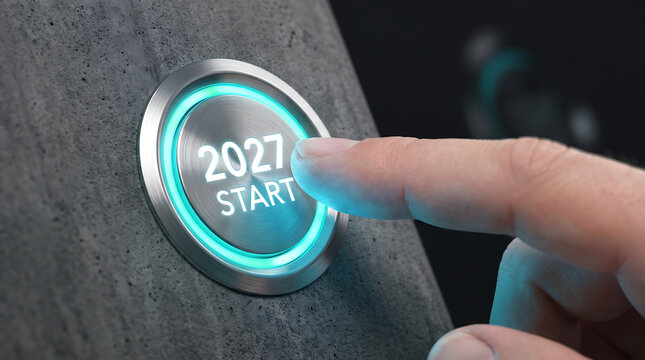 A close-up of a human finger pressing a glowing metallic push button in an abstract studio, representing technology activation and future planning for 2027.