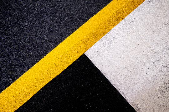 Abstract Geometric Car Park Floor Paint Markings Featuring Bold Yellow, White And Black Lines