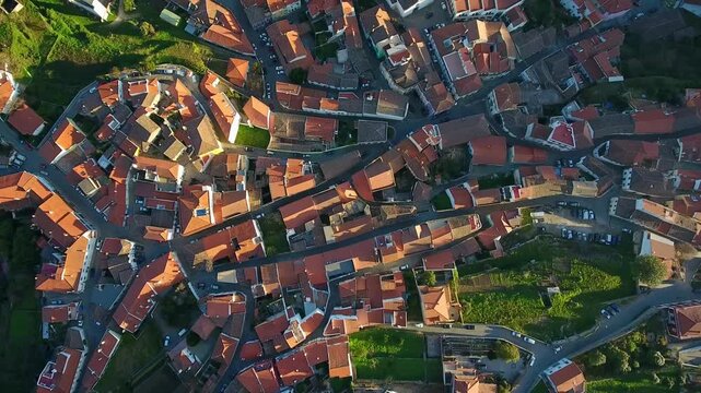 Aerial drone flight over the traditional village of monchique in the algarve region of portugal, showcasing the charming terracotta rooftops and winding streets bathed in warm sunlight