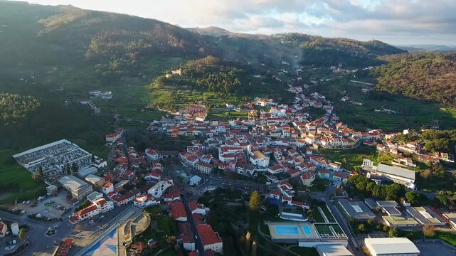 Majestic aerial view of the historic town of monchique nestled in the green mountains of the algarve region in portugal, beautifully illuminated by the warm light of the setting sun