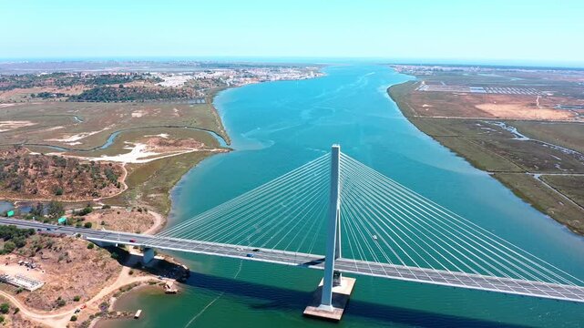Majestic aerial view of the guadiana international bridge spanning the river between ayamonte, spain, and vila real de santo antonio in the algarve region of portugal under a clear blue sky