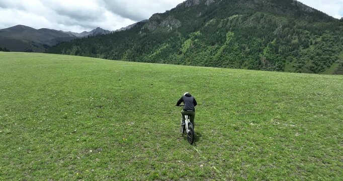 Aerial footage of woman riding mountain bike on beautiful forest mountain trail