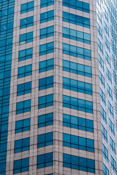 Exterior of modern corporate office building featuring glass windows and stone facade