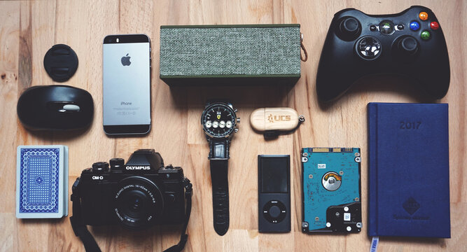 Flat lay of modern electronic gadgets and accessories on a wooden desk