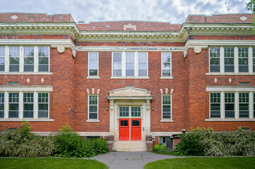 Colonial building with red entrance doors and symmetrical classical facade. © TOimages