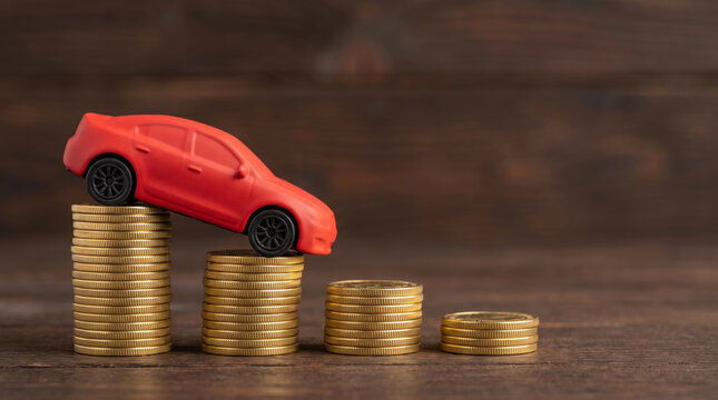 Coins stacked decrease across red car scale concept. Finance investment recession crisis. money budget saving expense, value reduction down decayed, risk loss