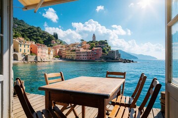 Fototapeta premium Empty wooden table, chairs on sunny pier overlook blue sea, colorful coastal town. Summer vacation view from balcony with Mediterranean buildings, hills, bright sky. Peaceful seaside terrace offers