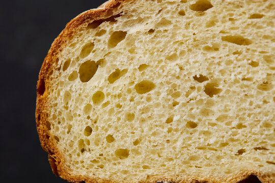 Fresh sourdough wheat bread crumb texture macro shot. Dark background. Close up. Copy space. Top view.