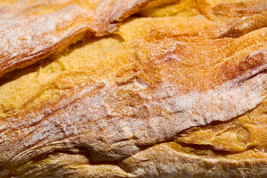 Ciabatta, sourdough bread crust texture background full frame. Close up. Copy space.