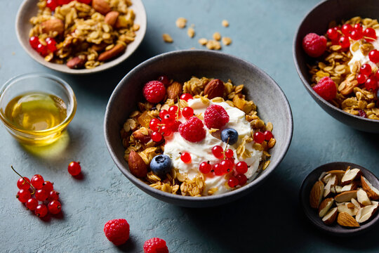Healthy breakfast. Granola, muesli with yogurt and fresh berries. Grey background. Close up.