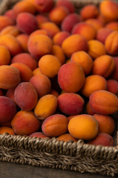 Fresh apricot pile in woven basket at a market