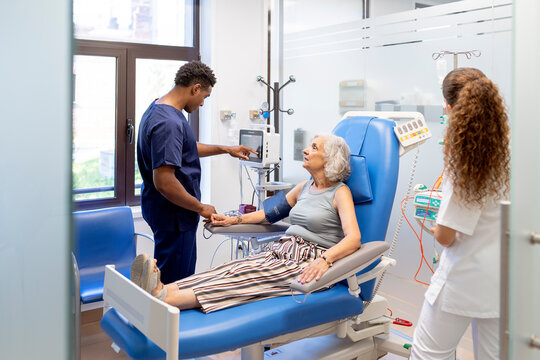 Senior patient receiving dialysis treatment with medical staff