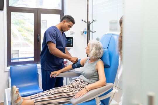 Healthcare professional checking blood pressure of senior patient
