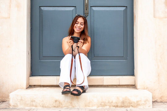 Smiling woman review camera photos on doorstep