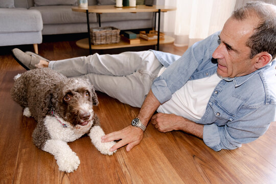 Senior man relaxing on the floor with his dog at home