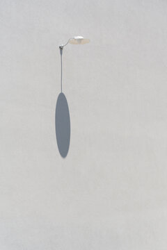 Minimal wall lamp casting an oval shadow