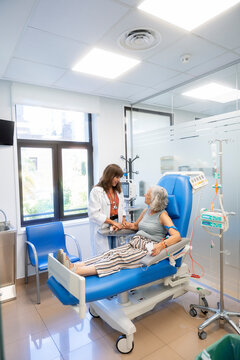 Doctor comforting patient receiving medical infusion treatment