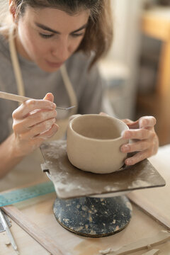 Ceramic artist refining handmade clay cup