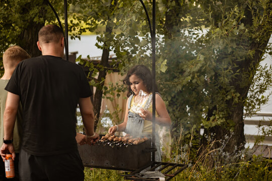 Family barbecue in backyard during summer weekend vacation